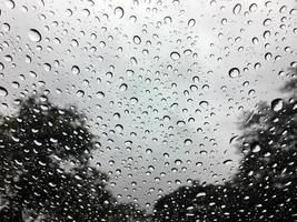 gota de lluvia en el fondo de textura de adstract de vidrio de coche con luz de borde, luz solar foto