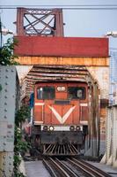 Train running on ancient railway on Long Bien bridge in Hanoi photo