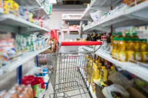 Shopping cart parked in aisle food and raw material at grocery store photo