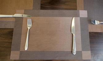 Tableware knife and fork with table cloth on wood table photo