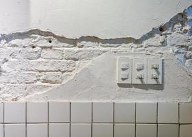 Light dimmer switch with light switch on broken wall photo