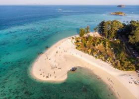 Tourists on the beach with coral reef in tropical sea at Lipe island photo