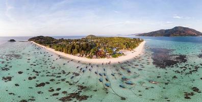 hermoso mar tropical con botes de cola larga y resort en la isla lipe foto