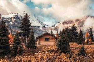 Wooden hut with Assiniboine mountain in autumn forest at provincial park photo