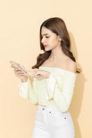 Portrait of serious concentrated attractive woman using mobile phone in hand on isolated pastel color background. typing message, design and advertising concept. photo