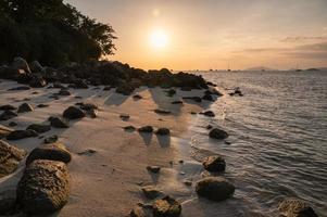 Seascape with rocks on coastline in tropical sea on sunset photo