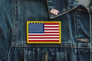 feliz día de la independencia 4 de julio. parche textil de la bandera americana en una chaqueta vaquera y pin americano foto