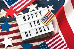 feliz día de la independencia 4 de julio. vista superior de la caja de luz con el texto feliz 4 de julio, banderas americanas y estrellas foto