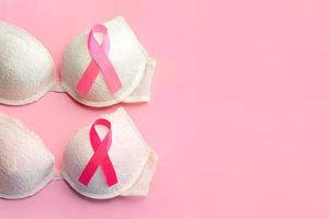 concepto de cáncer de mama. vista superior de los sostenes de las mujeres y el símbolo de la cinta rosa conciencia del cáncer de mama foto