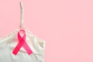 concepto de cáncer de mama. vista superior de la camiseta de lencería y el símbolo de la cinta rosa conciencia del cáncer de mama foto