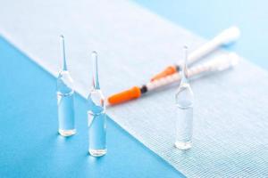 Ampules and syringes on steile bandage surface. Close up image of medical supplies. photo
