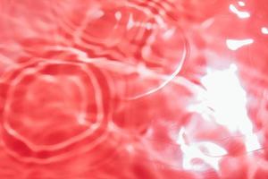 Red abstract background in blur. Blurry liquid surface with ripples. photo