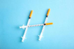 Medical syringes on blue background. Simple medicine concept flat lay. photo