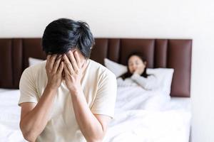 Husband feels stressed and pressured from the problem of erectile dysfunction while the disgruntled wife lay in bed after having sex photo
