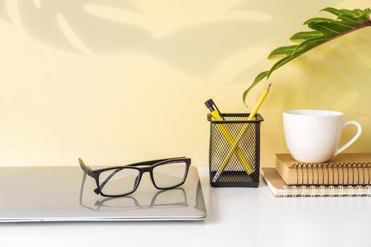 maqueta de espacio de trabajo moderno y elegante con suministros de oficina para computadora portátil y escritorio con fondo de color y espacio para copiar foto