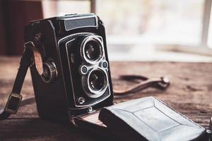 Old retro camera on old wooden background photo