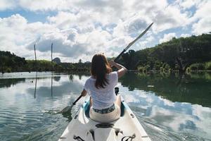 Young woman tourist paddling the kayak at klong root in Krabi, Thailand photo