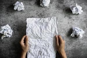 Hand holding crumpled paper on grunge background, Creativity problems concept photo