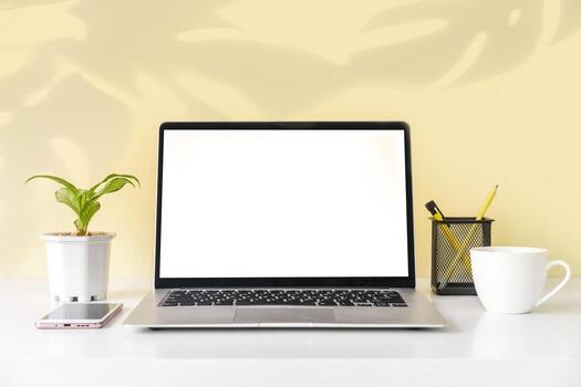 maqueta de espacio de trabajo moderno y elegante con computadora portátil en blanco y suministros de oficina de escritorio con fondo de color y espacio de copia foto