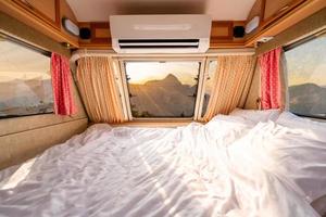 Mattress in camper van and beautiful landscape while road trip traveling on vacation photo