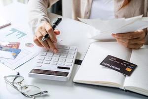 Stressed young woman calculating monthly home expenses, taxes, bank account balance and credit card bills payment, Income is not enough for expenses photo