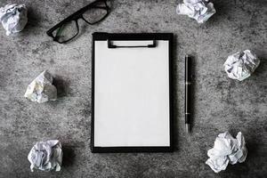 Crumpled paper balls with eye glasses and file folder on desk office, Creativity problems concept photo