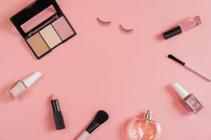 cosméticos de mujer y maquillaje sobre fondo rosa, vista superior foto