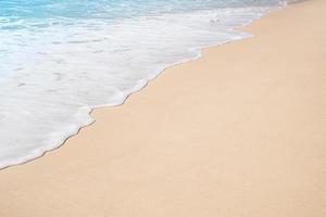Soft ocean wave on tropical sandy beach in summer background with copy space photo