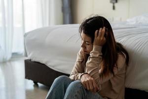 Lonely young woman feeling depressed and stressed sitting in the dark bedroom, Negative emotion and mental health concept photo