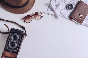 cámara retro con accesorios de viaje y artículos sobre fondo blanco con espacio de copia, concepto de viaje foto