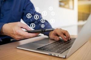 Hand using mobile phone with online transaction application while working with laptop, Concept financial technology and ICO Initial coin offering business financial internet innovation technology photo