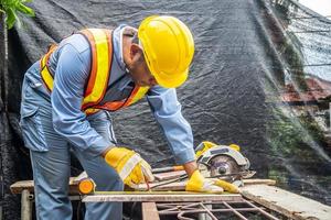 Construction worker are using tape measurements to measure planks and pencil are used to write, Close up of male hands measuring wood flooring, Construction industry, housework do it yourself. photo