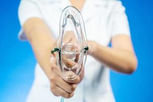 Doctor puts on oxygen mask to connect a patient losing consciousness to an artificial respiration device, Emeregency and first aid concept. photo