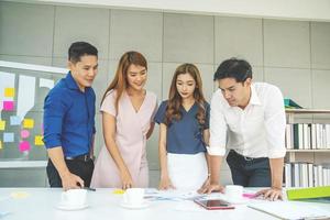 Business people standing at the table and discussing new project,  Group business executives looking at papers on table and brainstorming while working together at conference room in a modern office photo