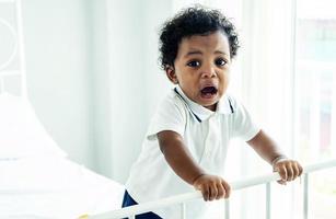 Closeup of adorable little african american baby boy crying on the bed - Black people photo