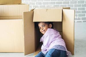 Relocating delivery services. Delivering happiness, African american cute baby girl enjoy playing with cardboard box at home, Insurance post package. Deliver your treasures. Storage for toys. photo