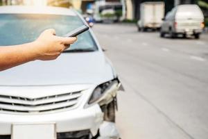 Man using smartphone help calling car mechanic at roadside after traffic accident photo