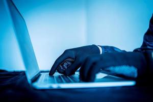 Close up hacker hand typing keyboard input code for register system structure or unlock password on laptop in darkness operation room, cyber security and stealing data concept photo