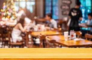 fondo de mesa de madera vacía de espacio libre para su restaurante café borroso en fondo oscuro, para exhibición de productos de montaje foto