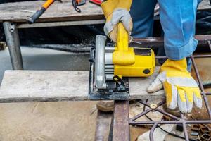 Carpenter using circular saw for cutting wooden boards with power tools, construction and home renovation, repair and construction tool photo