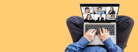 Online business meeting. Multiracial business people working from home by a video conference. Top view at a laptop screen with webcam shots of diverse people and hands of a man on a keyboard photo