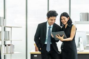 Professional asian business woman holding document file on hand and talk about business plan with business man in the workplace. photo