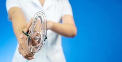 Doctor puts on oxygen mask to connect a patient losing consciousness to an artificial respiration device, Emeregency and first aid concept. photo