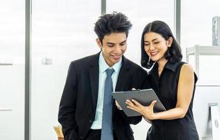 Professional asian business woman holding document file on hand and talk about business plan with business man in the workplace. photo