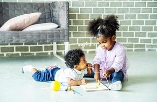 Cute black african american little girl and boy drawing book on floor indoors,  African people - Children photo