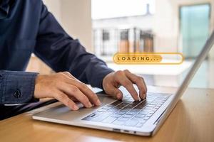 Detail of hand businessman using a laptop on a table, Download Upload data information and business progressive concept, Loading icon on screen. photo