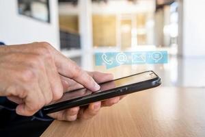 Hotline service, Customer support hotline Contact us people connection. Businessman using Smart Phone with the email, call phone, address, Chat message icons photo