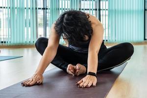 grupo de mujeres y hombres deportistas que se estiran en el gimnasio, concepto de vida saludable y equilibrio natural entre el desarrollo corporal y mental, uso de ropa deportiva, cierre interior, concepto de entrenamiento de estilo de vida foto