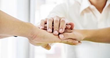 Business Team Stack Hands Support Concept. Four business people in formal wear standing and discussing and shake hands and folding their hands on hands of success concept Symbol of cooperation photo