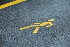 Yellow pedestrian sign on sidewalk, road yellow marking for traffic safety near highway photo